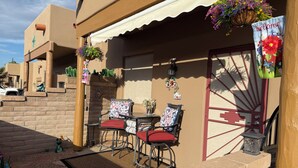 A patio with outdoor seating, a decorative wall, and a welcome sign. - Cozy 2 bed 2 bath Santa Fe style, 55+ Senior Community Green Valley town home. (Green Valley)