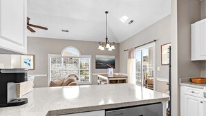 Una cocina moderna con encimera de granito, electrodomésticos integrados y un comedor con vistas al exterior.
