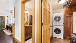 A laundry area with two washing machines, wooden cabinets, and a green door. - National Parks - Cozy stay and UFO Sightings (Alton)