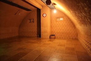 A dimly lit attic room with tiled floors, a clock, and a small window. - Lamer Hotel & Seawater Spa Busan (Busan)