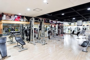 A gym with various exercise equipment, a mirror wall, and a wooden floor. - Lamer Hotel & Seawater Spa Busan (Busan)