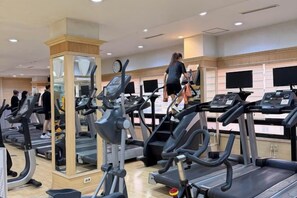 A gym with multiple treadmills, a mirrored column, and a person using a treadmill. - Lamer Hotel & Seawater Spa Busan (Busan)