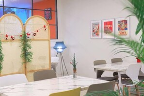 A modern dining area with a white table, chairs, and a blue floor lamp. - Lamer Hotel & Seawater Spa Busan (Busan)