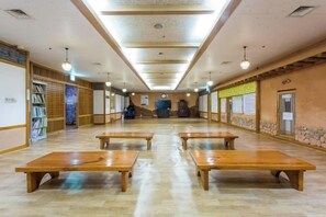 A long hallway with wooden benches, a central staircase, and a traditional Japanese interior design. - Lamer Hotel & Seawater Spa Busan (Busan)