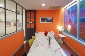 Un salón de conferencias con una mesa larga, sillas y un gran ventanal con vistas.