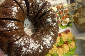 A chocolate bundt cake with powdered sugar on top. - Sands of Time Apart Hotel (Baku)