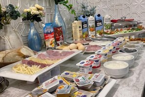 A buffet table with various food items, including meats, cheeses, and condiments. - Sands of Time Apart Hotel (Baku)