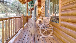 A wooden porch with a bench and a wheelbarrow, overlooking a natural landscape. - Great for Gatherings! Family Cabin in Lakeside (Lakeside)