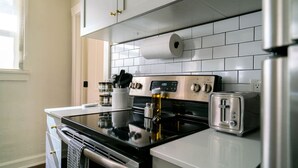 A modern kitchen with stainless steel appliances, white cabinetry, and a tiled backsplash. - Relaxing & Central SLC Apt near Trolley Square (Salt Lake City)