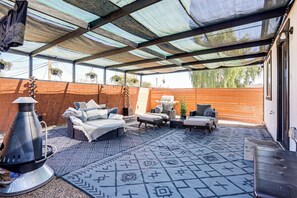A covered patio with outdoor furniture, a grill, and hanging plants. - Hike, Golf & Explore: Pet-Friendly Phoenix Casita! (Phoenix)