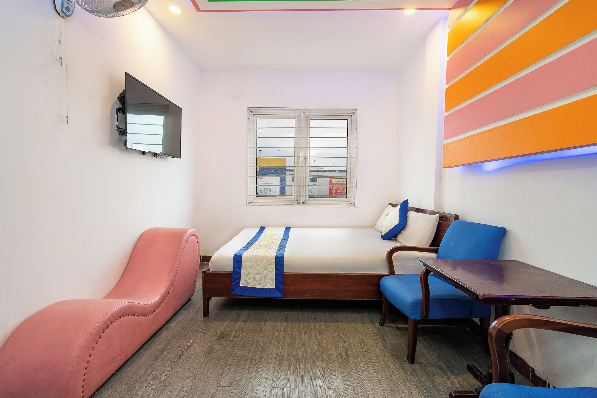 Una habitación pequeña y funcional con cama, escritorio, silla y ventana.