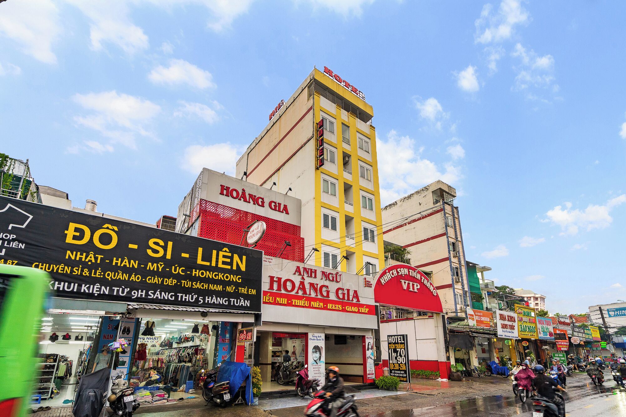 A multi-story building with signage for a hotel and various shops.