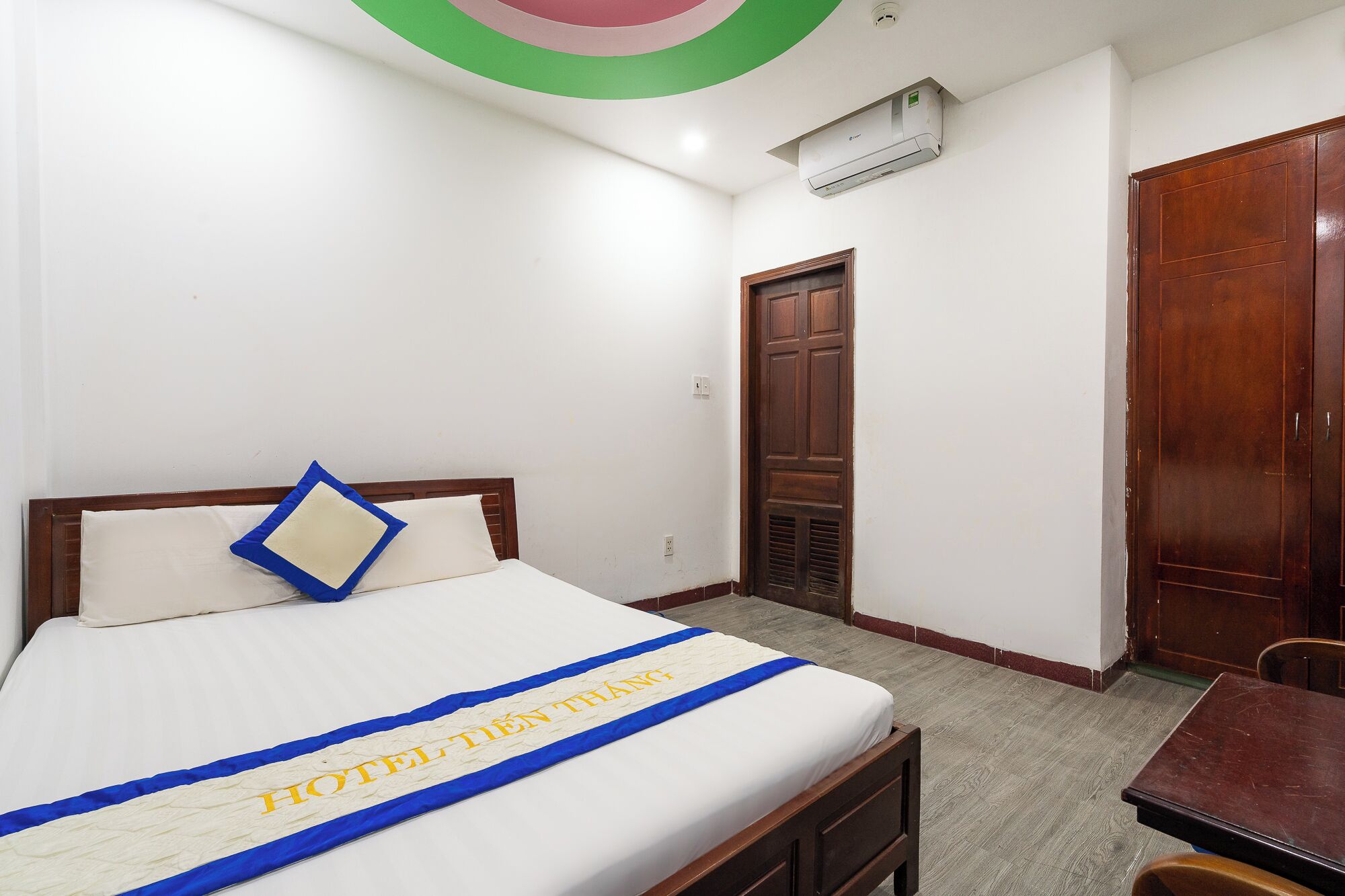 Une chambre d’hôtel avec un lit, une porte en bois et une petite table.