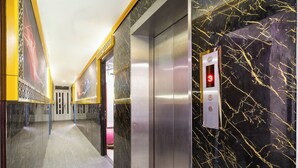 A modern elevator with a marble wall and a digital display. - Collection O District Tan Phu - Tien Thang Hotel  (Ho Chi Minh City)
