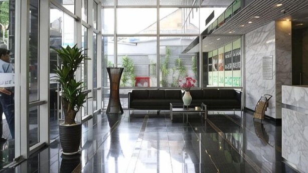 A modern lobby with glass walls, a seating area, and potted plants. - Lancaster Ho Chi Minh Serviced Apartment Official (Ho Chi Minh City)