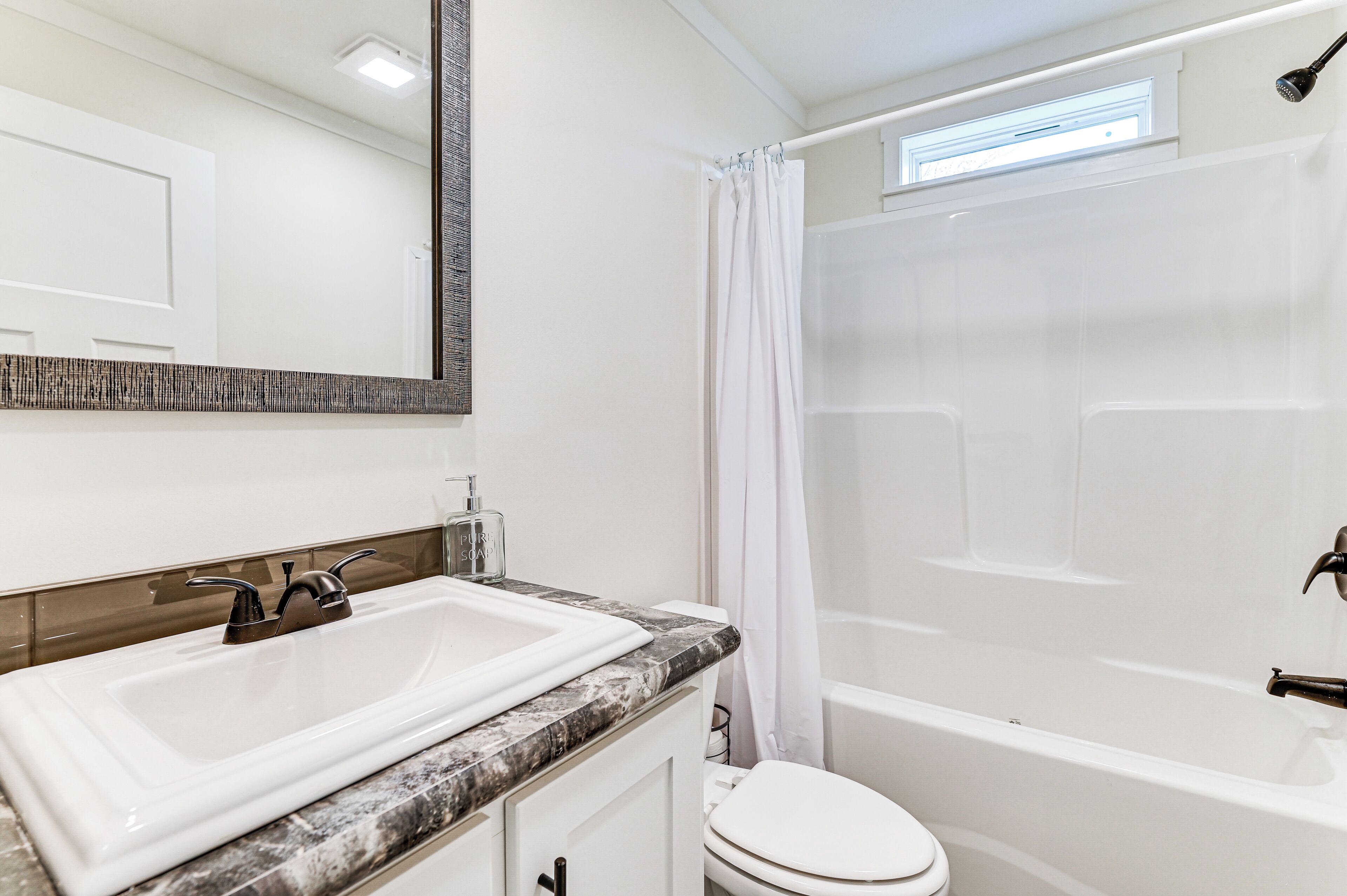 A modern bathroom with a white sink, a toilet, and a bathtub.