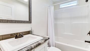 A modern bathroom with a white sink, a toilet, and a bathtub.