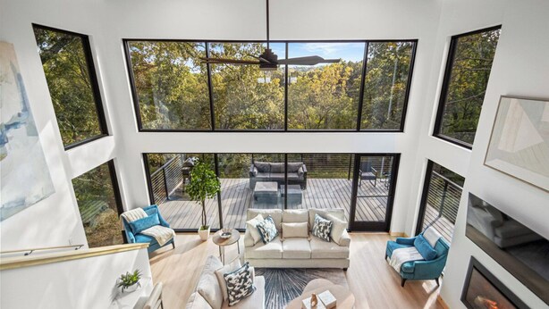 A spacious living room with a large window, a fireplace, and a cozy seating area.