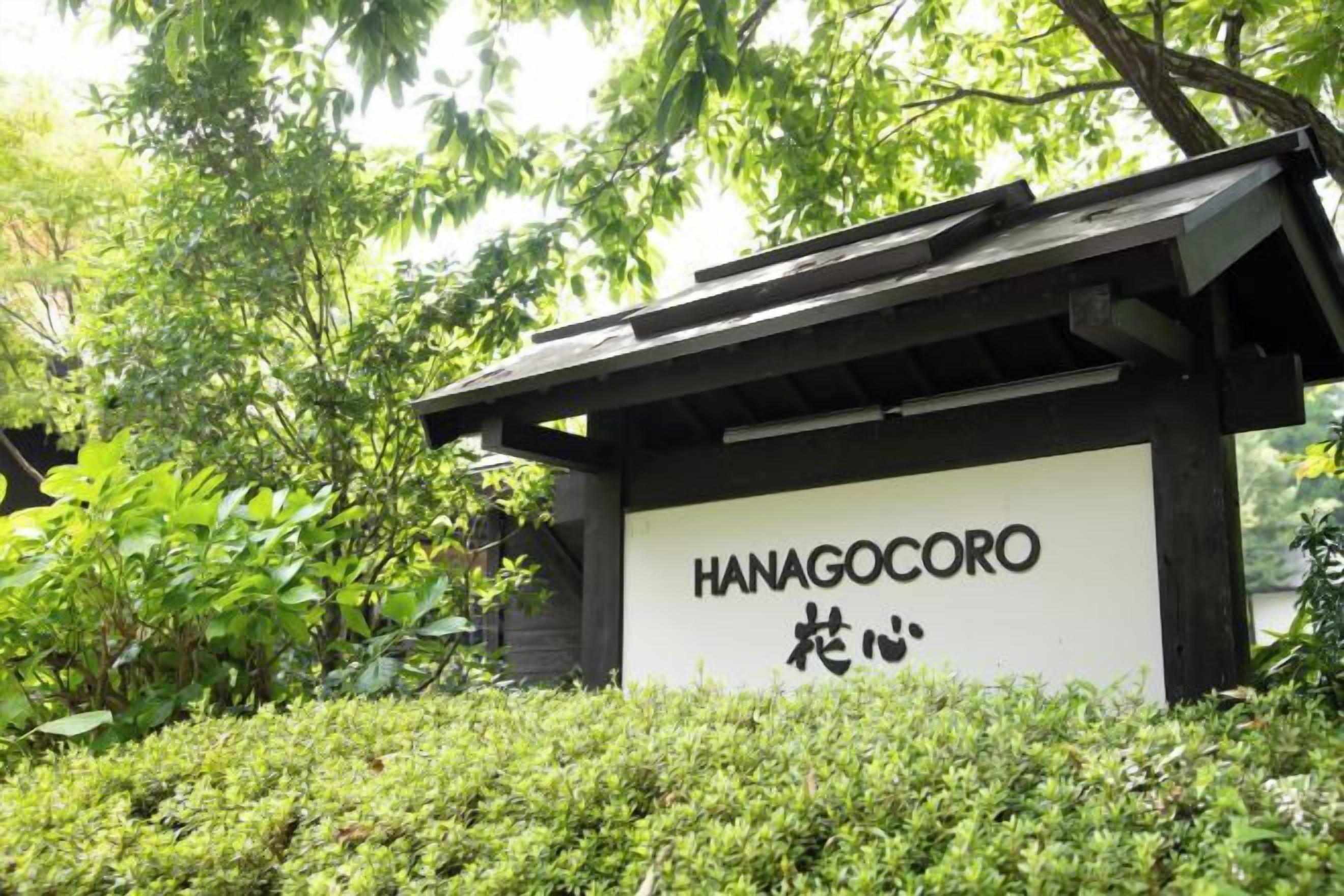 Une enseigne portant l’inscription « HANAGOCORO », entourée de verdure.