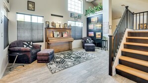 A spacious living room with a piano, a sofa, a rug, and a staircase. - Labor Day Weekend Special: Flexible Check-In/Out! (Phoenix)