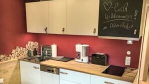 A compact kitchen with a wooden countertop, white cabinets, and a chalkboard with a welcome message. - Beautiful apartment for 2 people with WIFI, TV, balcony and pets allowed (Thurmbach)