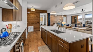 Una cocina moderna con armarios de madera, una isla central y un ventanal con vistas.