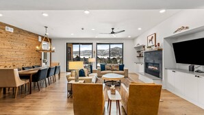 Un espacio habitable amplio con una pared de madera, una chimenea y un televisor grande.
