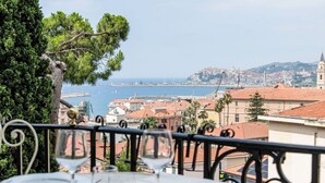 Mesa lista para comer con vista a una ciudad costera.