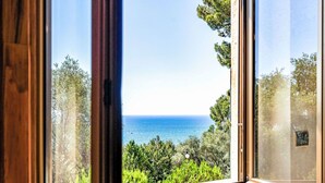 Une fenêtre donnant sur la mer et la verdure.