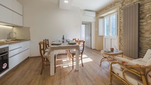A modern kitchen with white cabinets and a dining area with a wooden table and chairs. - Wonderful  villa for 6 people with WIFI, A/C, TV and terrace (San Vito-cerreto)