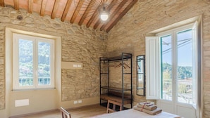 A room with stone walls, a bunk bed, a large window, and a bed with towels. - Wonderful  villa for 6 people with WIFI, A/C, TV and terrace (San Vito-cerreto)