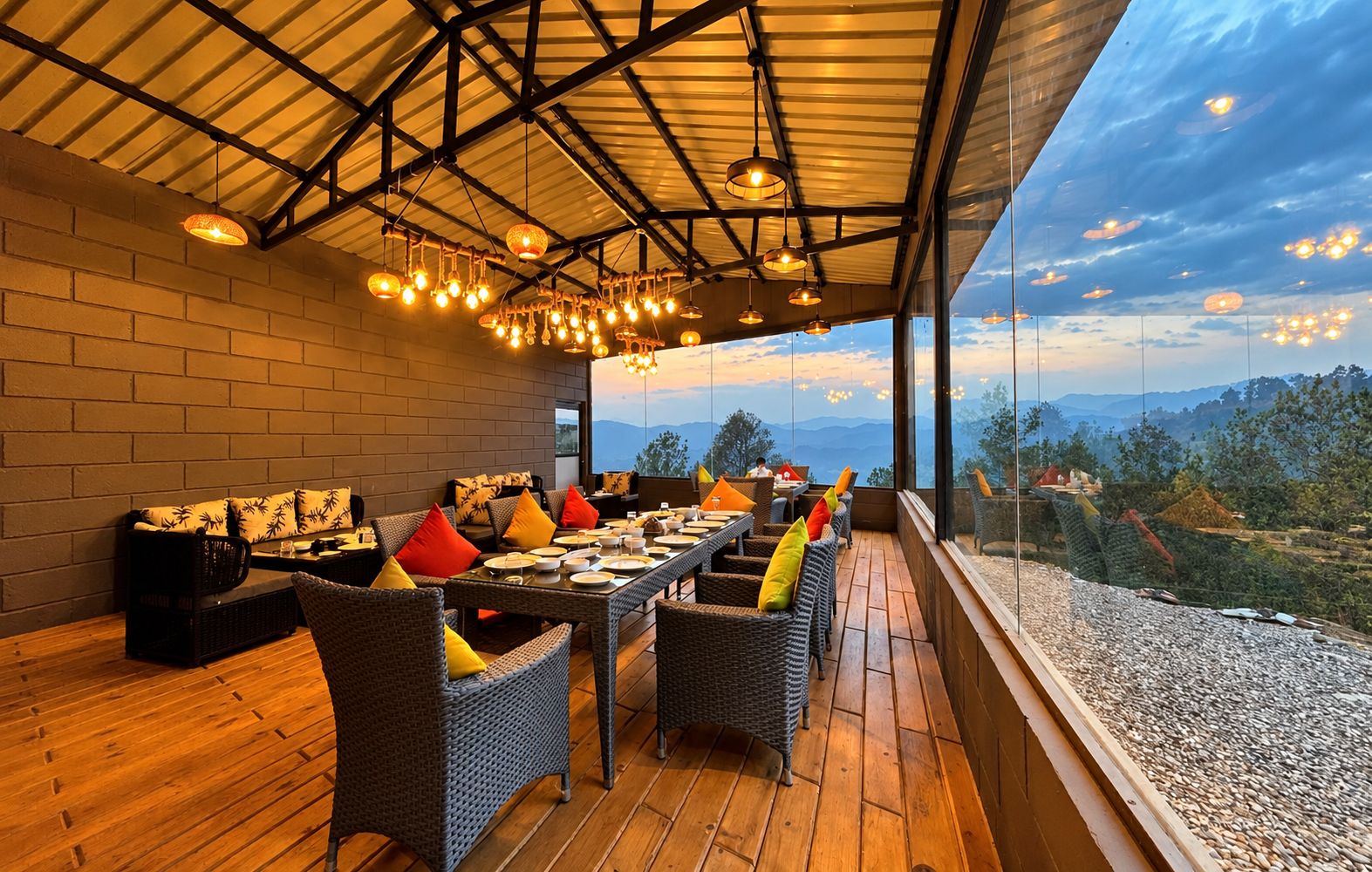 An outdoor dining area with wicker furniture and a view of the landscape.