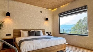 Ein Schlafzimmer mit Bett, Nachttischen, einem Fenster mit Aussicht und Pendelleuchten.