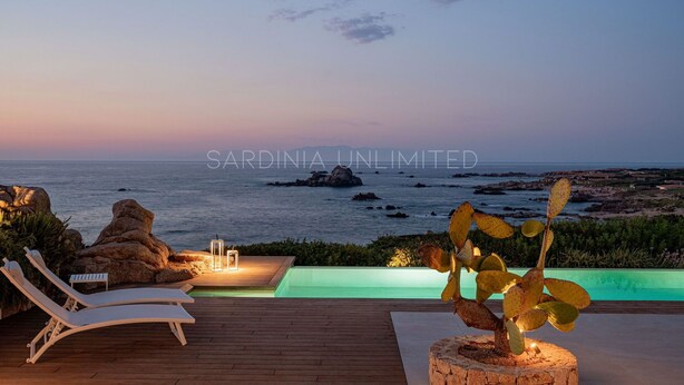 A sunset view from a deck with lounge chairs, a small pool, and a rocky coastline. - Villa Janas Eterea - Sardinia Unlimited (Portobello Di Gallura)
