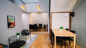 A modern meeting room with a wooden table, black chairs, and a glass table with a potted plant. - Swing & Pillows at 87 Chulia St (George Town)