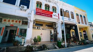 A street view of a building with multiple businesses, including a restaurant and a trading company. - Swing & Pillows at 87 Chulia St (George Town)
