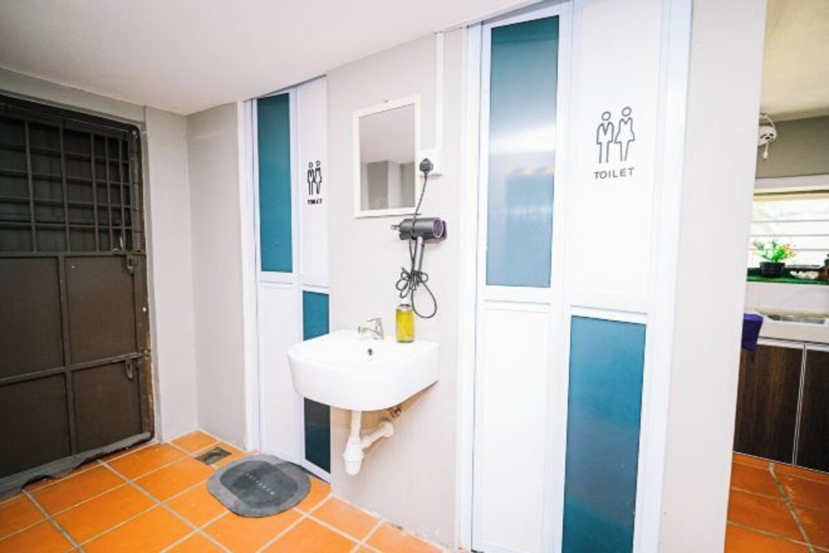 Een badkamer met een wit wastafel, een spiegel en een toilet.