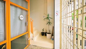 L’entrée d’un hôtel, avec un panneau indiquant « fermé », un escalier et des plantes en pot.