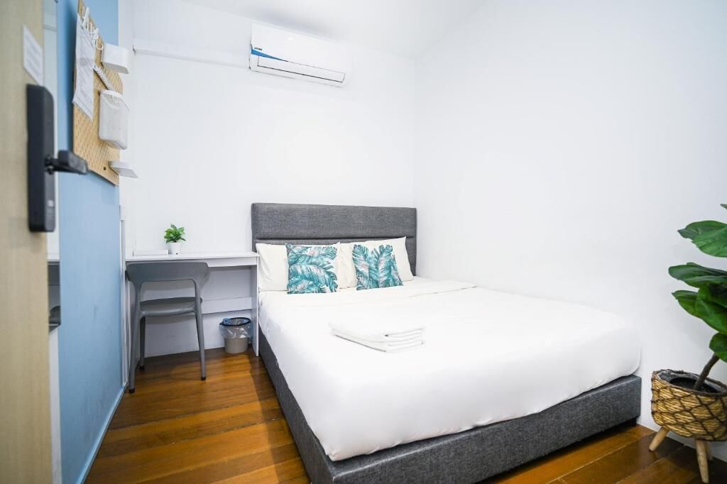 A neatly arranged bedroom with a bed, a desk, and a chair.