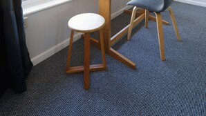 A room with a large window, a wooden table, two chairs, and a carpeted floor. - Spacious 2-Bedroom Flat Near Rottingdean Beach & Windmill (Brighton and Hove)
