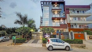 A multi-story building with a modern architectural design, featuring balconies and large windows. - Hotel Vibe Blue (Noida)