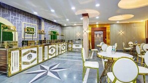 A hotel lobby with a reception desk, seating area, and decorative elements. - Hotel Vibe Blue (Noida)