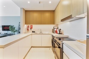 Una cocina moderna con horno empotrado, microondas y pileta.