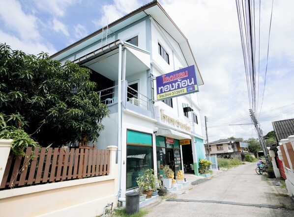 A two-story building with a signboard advertising services. - Thongkon Hotel (Surin)