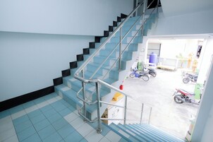 Una escalera con barandillas de metal que conduce a un espacio exterior con motocicletas estacionadas.