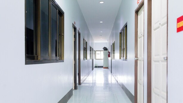 A long, narrow hallway with doors on both sides, leading to rooms. - Thongkon Hotel (Surin)