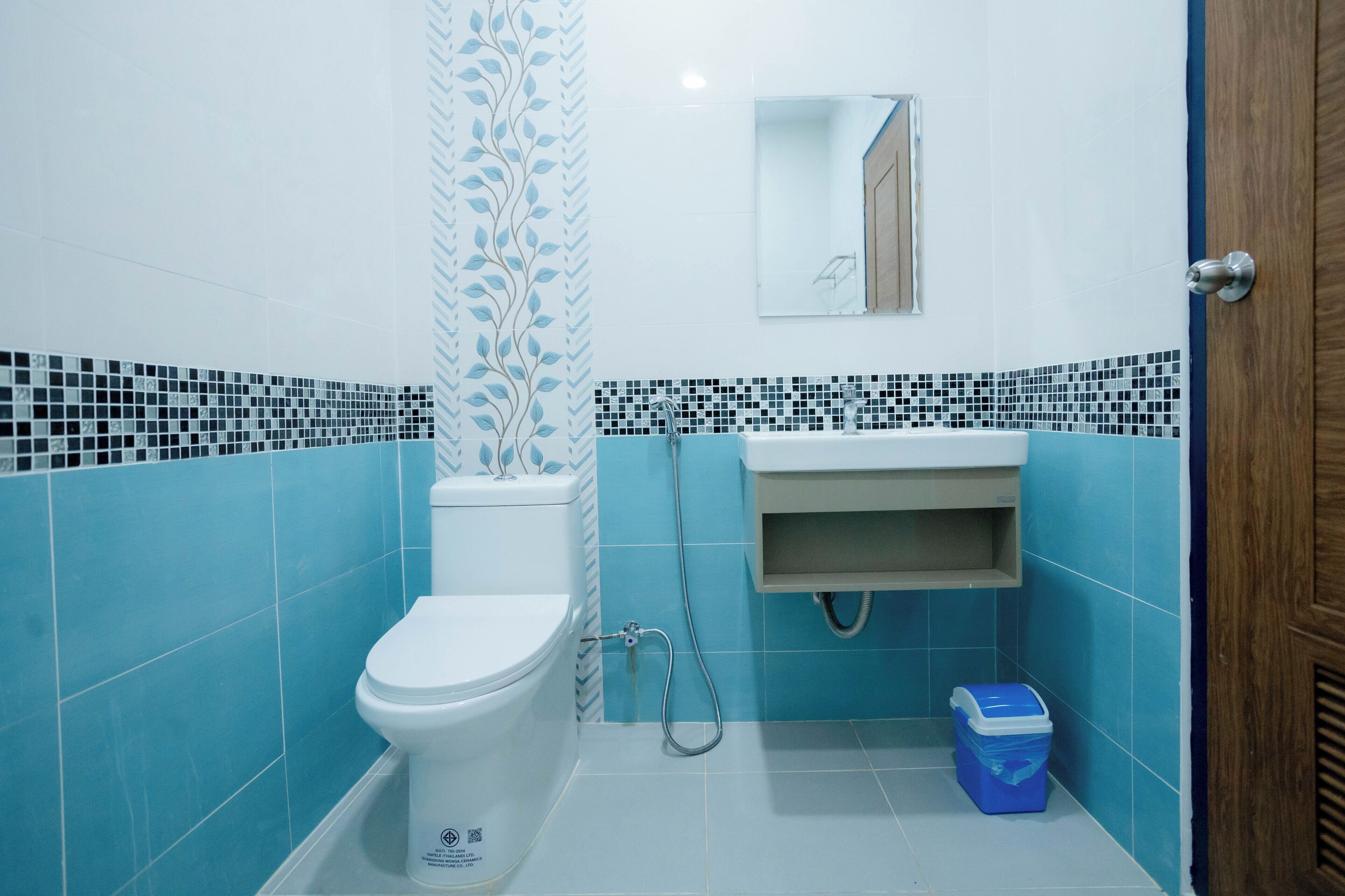 A bathroom with a toilet, sink, and shower area.