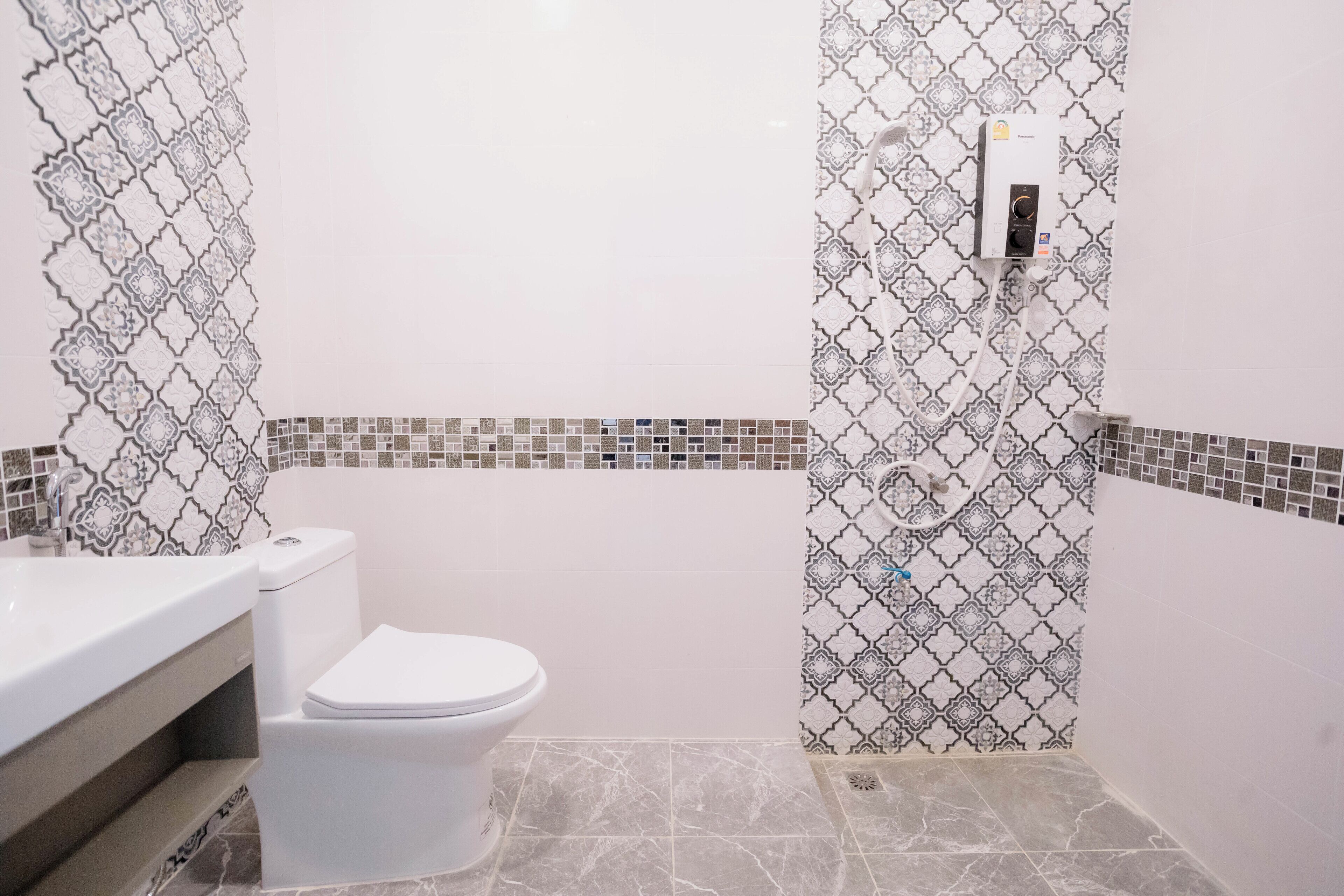 A bathroom with a toilet, sink, and shower area.