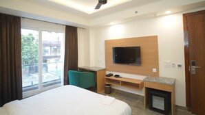 Una habitación de hotel con una cama, un escritorio, un televisor y vistas al exterior.