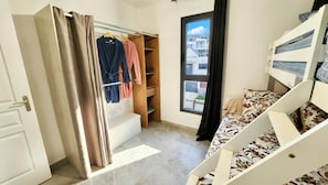 A bedroom with a bed, a wardrobe, a window, and a staircase. - Modern, fully equipped villa—heated pool, panoramic view—near the airport (Beauséjour (Sainte-Marie))